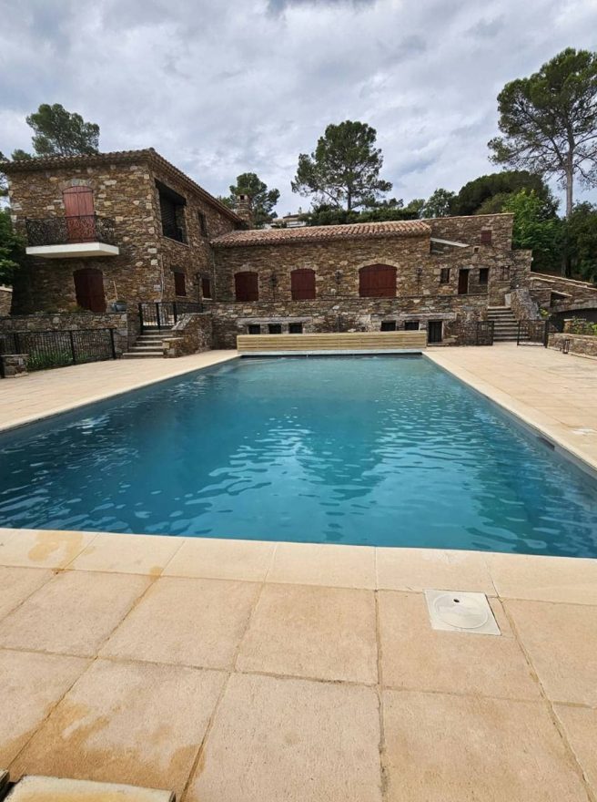 Revêtement polyester créé sur un bassin béton, devant une bastide en pierre